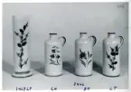 En vas och tre krus med olika dekorer från Bo Fajans, formgivare Eva Jancke-Björk, 1900-talets mitt.