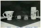 Bägare, muggar samt en vas från Bo Fajans, formgivan av Allan Ebeling och Eva Jancke-Björk, 1900-talets mitt.