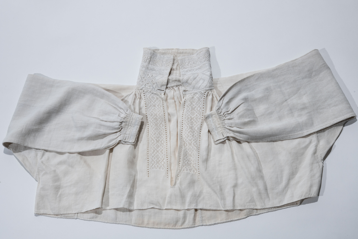 Brudedrakt med skjørt, liv, skjorte, forkle, stølebelte og offerdåse. 
Rødt bunadsliv av nordmørstype i glanset ullstoff med ufarget for. "Sølvkanter" langs åpningen på begge sider. 
Linskjorte der nedre del er av grovere tekstil. Øvre del har svært bred krage fullbrodert med hvitsøm og ermer med hvitsøm. 
Skjørt i rødt glanset ullstoff, fronten har innsydd et rødt ullstoff i en stripe som dekkes av forkleet. Langs nedre kant en maskinlaget silkebord. Omfattende appliklasjonsbroderier  i blomstermønster over store deler av nedre del  av skjørtet. Skjørtet er sydd sammen av flere deler av samme tekstil.
Offerdåse av vanlig modell av sølv med utklipt malteserkors hengende fra bunnen, hengende ruterformede sølvstykker fra hver side og bunnen av korset og fra selve offerdåsen på hver side av korset. Offerdåsen er på kjede som avslutter i to ruterformede figuerer med løkker til anheng på vher av ruterens sider. Inngravert geometrisk mønster.
Rødt stølebelte med støler av nordmørstype, mønster i form av tre talglys, i forgylt sølv med beltespenne av forgylt sølv. Fra hver av stølene henger to flate ringer.
Forkle med alternerende nedagående blomster og sikk-sakkmønster i silkestoff.