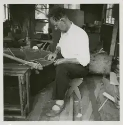 En man syr fast ett fiskenät i en metallring