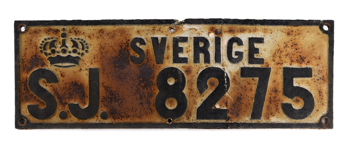 Två stycken rektangulära skyltar av gjutjärn med svart text på vit botten: "SVERIGE S.J. 8275". Mycket rostig.
Från godsvagn.