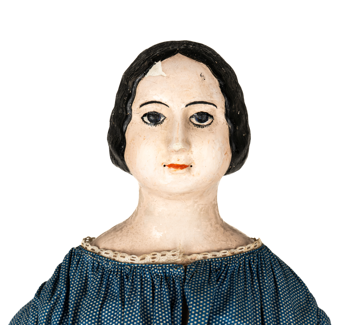 Docka, "Fedora", kroppen är svarvad av prosten Carl Steffenburg, Sundborn (född 1799), är iklädd linne, snörliv, byxor, stupp, tre underkjolar och blå klänning med vita prickar.
Kjolen har två volanger, skörtet på livstycket bildar en tredje volang.