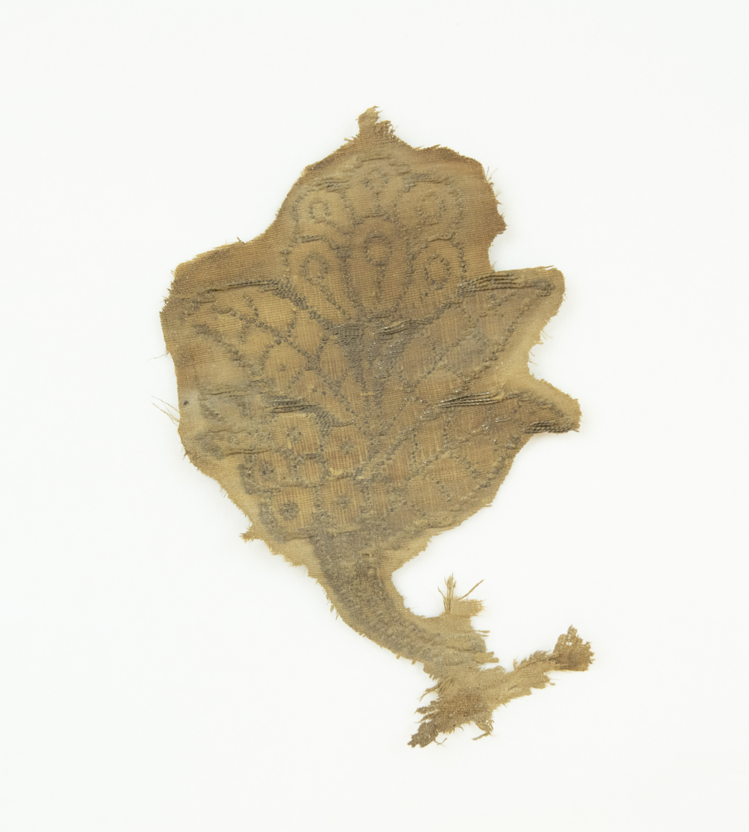 12 fragmenter av ulike størrelser og bevaringsgrad - det er bevart et nokså stort fragment med blomstermotiv, og flere av fragmentene er dekorerte. Fragmentene har antageligvis vært del av samme stykke stoff av ripsvev av silke- og/eller bomull og metalltråd. Samt fragmentene er det bevart to poser med vegetabilsk materiale funnet sammen med tekstilfragmentene. Materialet er foreløpig ukjent, men antatt å være planterester av humle, samt et trestykke som mulig kan være rest fra kisten, eller høvelflis som ikke var uvanlig å ha som underlag i kister på denne tiden. En pose med menneskehår er også bevart.