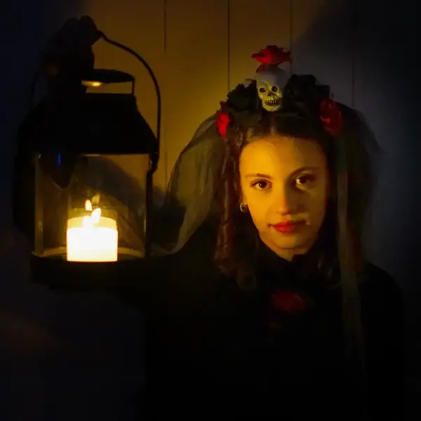 Ung jente med lyslykt og skummelt kostyme under Halloween på Norsk utvandrermuseum