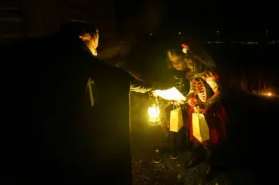 unge jenter i skumle kostymer får instruksjoner underveis i halloween på norsk utvandrermuseum