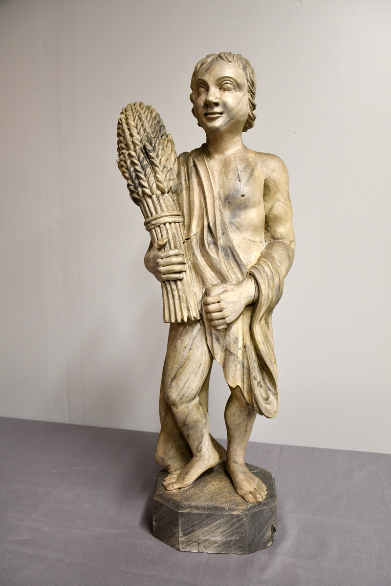 Treskulptur, gråmalt, marmorert. Symboliserer høsten.