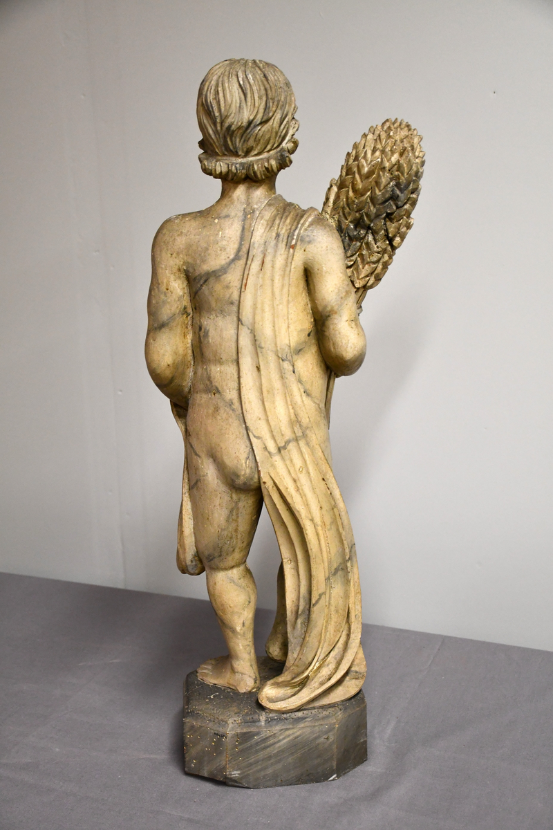 Treskulptur, gråmalt, marmorert. Symboliserer høsten.