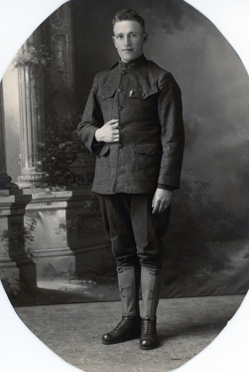 Grønn uniformsjakke i ull fra første verdenskrig. Fire knapper med ørnemotiv foran, samt to knapper på kragen.