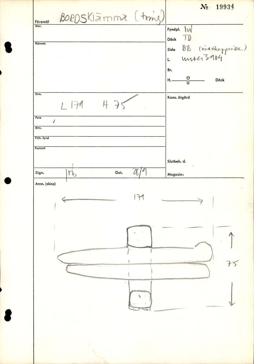 Bordklämma. Del av bordklämma bestående av den ena armen - eller käften. De ursprungliga kanterna och ändarna är i huvudsak väl bevarade. 840 mm från framänden finns  ett genomgående avlångt hål för tvärbrädan som håller ihop de två armarna. Eftersom märgen har lämnats kvar i ämnet har det bildats en märgspricka som löper längs översidans hela längd. Översidans kanter är fasade. Fasningens bredd är ca 25-30 mm. Ett genomgående, fyrkantigt spikhål med avtryck efter skalle på översidan, finns ca 55 mm från den smala ändens kant.  Verktygsspår på översidan, sannoligt av bilyxa. På den lätt välvda undersidan syns verktygsspår som troligen härrör  från en mer korteggad yxa. Det är gott om omotiverade och slumpvisa huggskador efter yxa, precis som om bordklämman vid något tillfälle har använts som huggkubbe. Föremålet är ganska oanfrätt.

För mer information se Dokumentationsblankett under Referenser – Länkade filer.