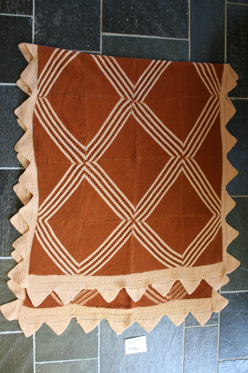 Sengeteppet er strikka av lapper som er samansydd, med rette masker, som ser ur som diagonale striper.