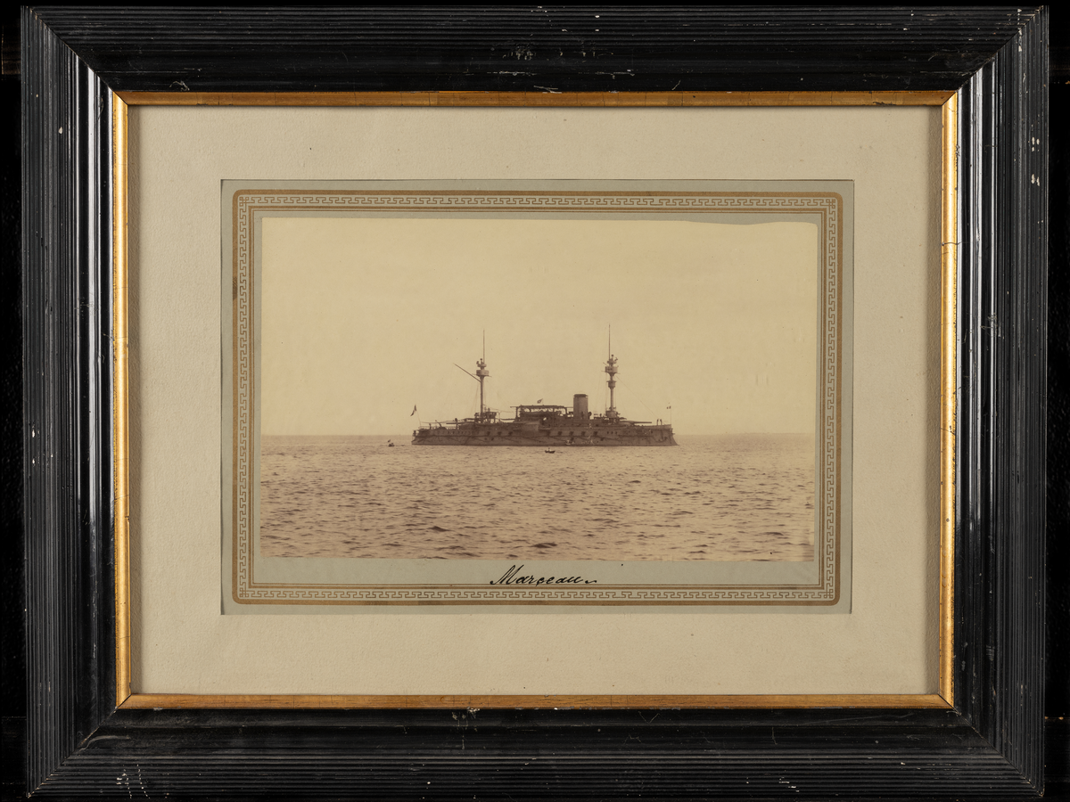 Fotografi i svart ram med guldkant.