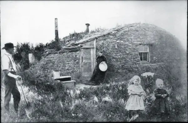 Foto av et torvhus fra 1882. Utenfor ser vi to barn med foreldrene i en arbeidssituasjon