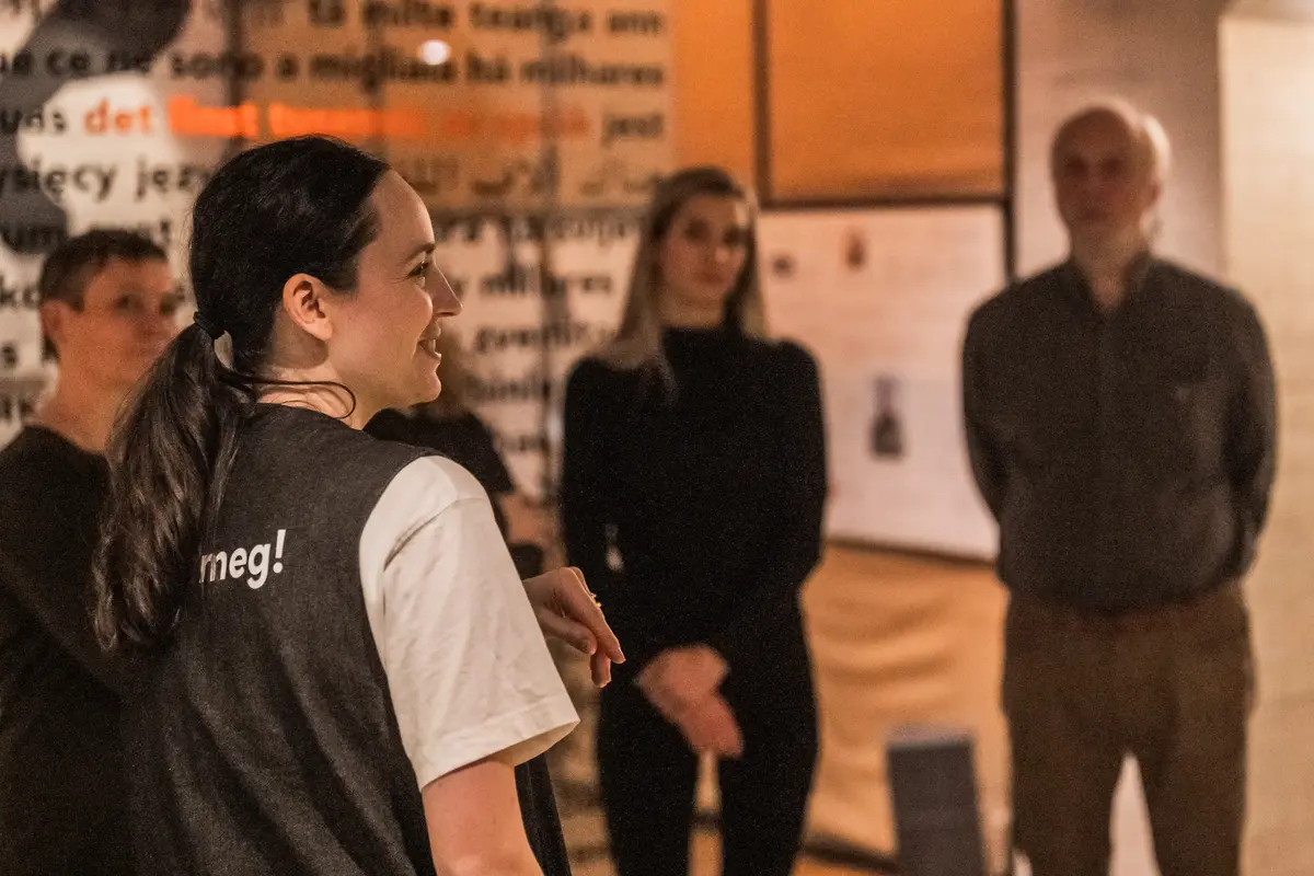 Bilete av ein museumsvert ved Aasentunet saman med ei gruppe besøkande