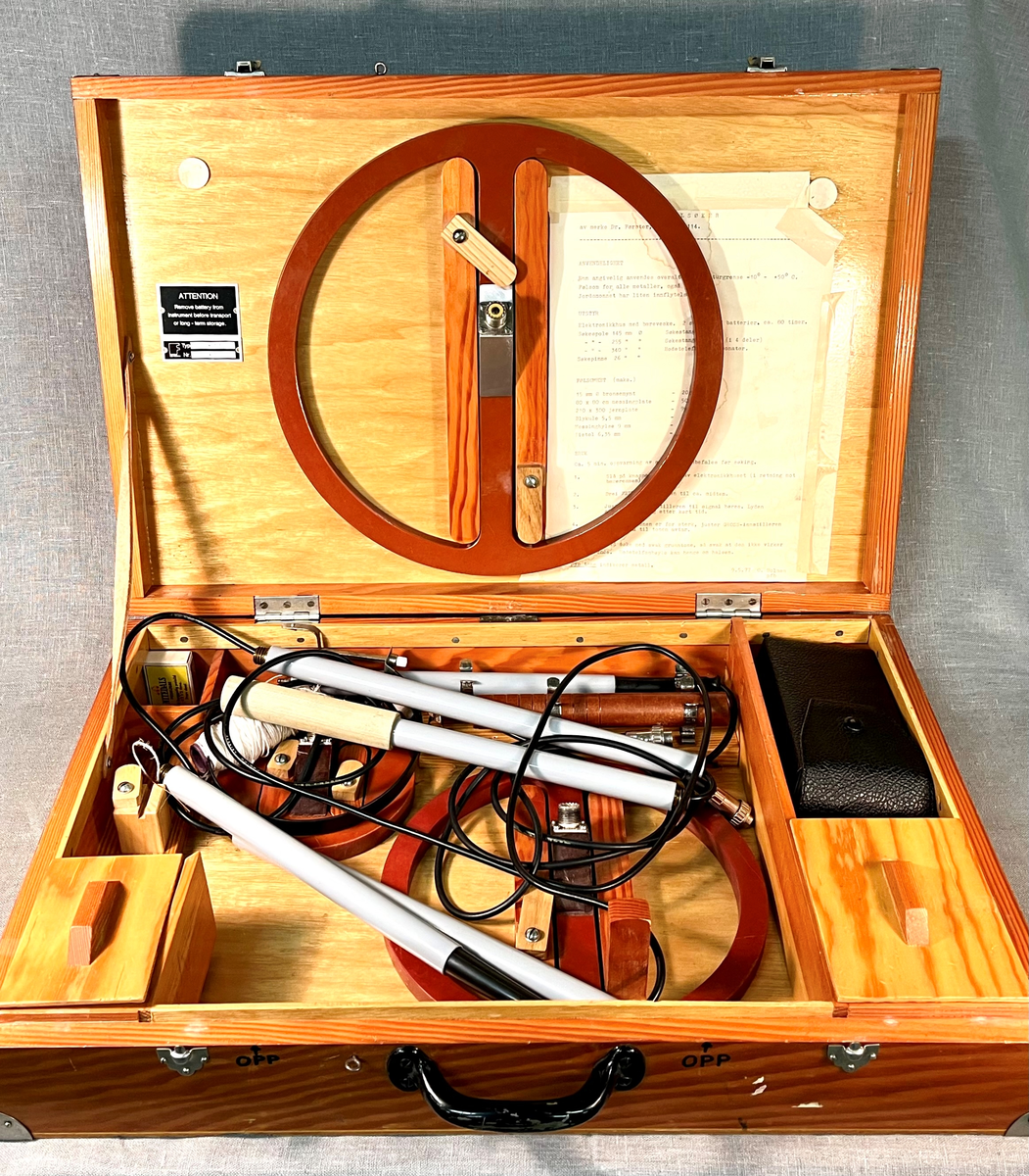 Sammenleggbar metalldetektor oppbevart i trekoffert. Bruksanvisning medfølger.