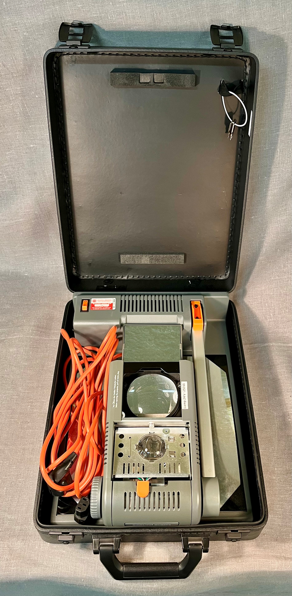 Sammenleggbar projektor oppbevart i trekoffert.