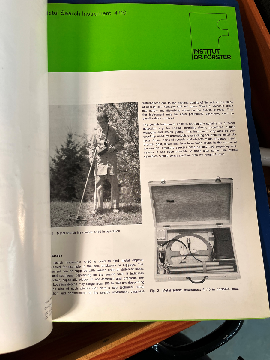 Sammenleggbar metalldetektor oppbevart i trekoffert. Bruksanvisning medfølger.