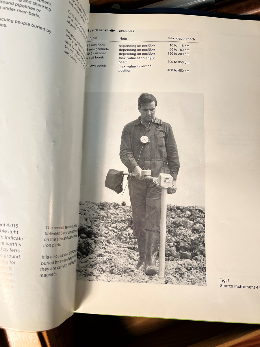 Sammenleggbar metalldetektor oppbevart i trekoffert. Bruksanvisning medfølger.