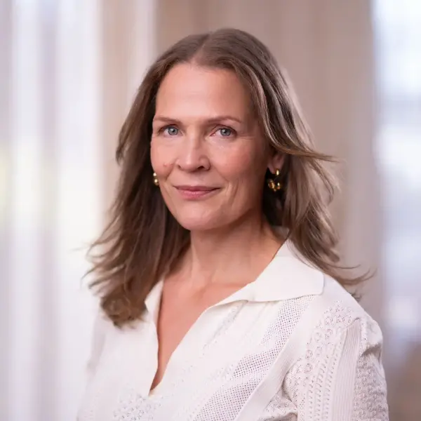 Dette er et portrett foto av en kvinne med langt hår. Det er Åsne Seierstad.