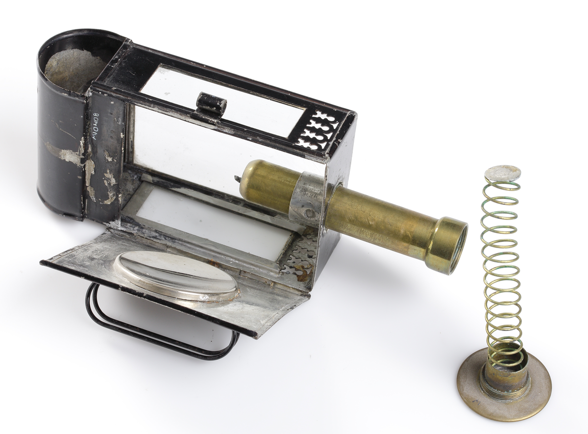 Lykta av svartlackerad bleckplåt med glas åt tre sidor (det främre slipat) och rökfång ovanpå. På insidan en rund, konkav och blank metallplatta för att reflektera ljuset, Ljushållaren avsedd för stearinljus. En mässingscylinder varit ljuset isättes underifrån, pressas upp av en spiral som sitter fäst vid cylinderns skruvbara botten.

Inskrivet i huvudkatalog 1939.