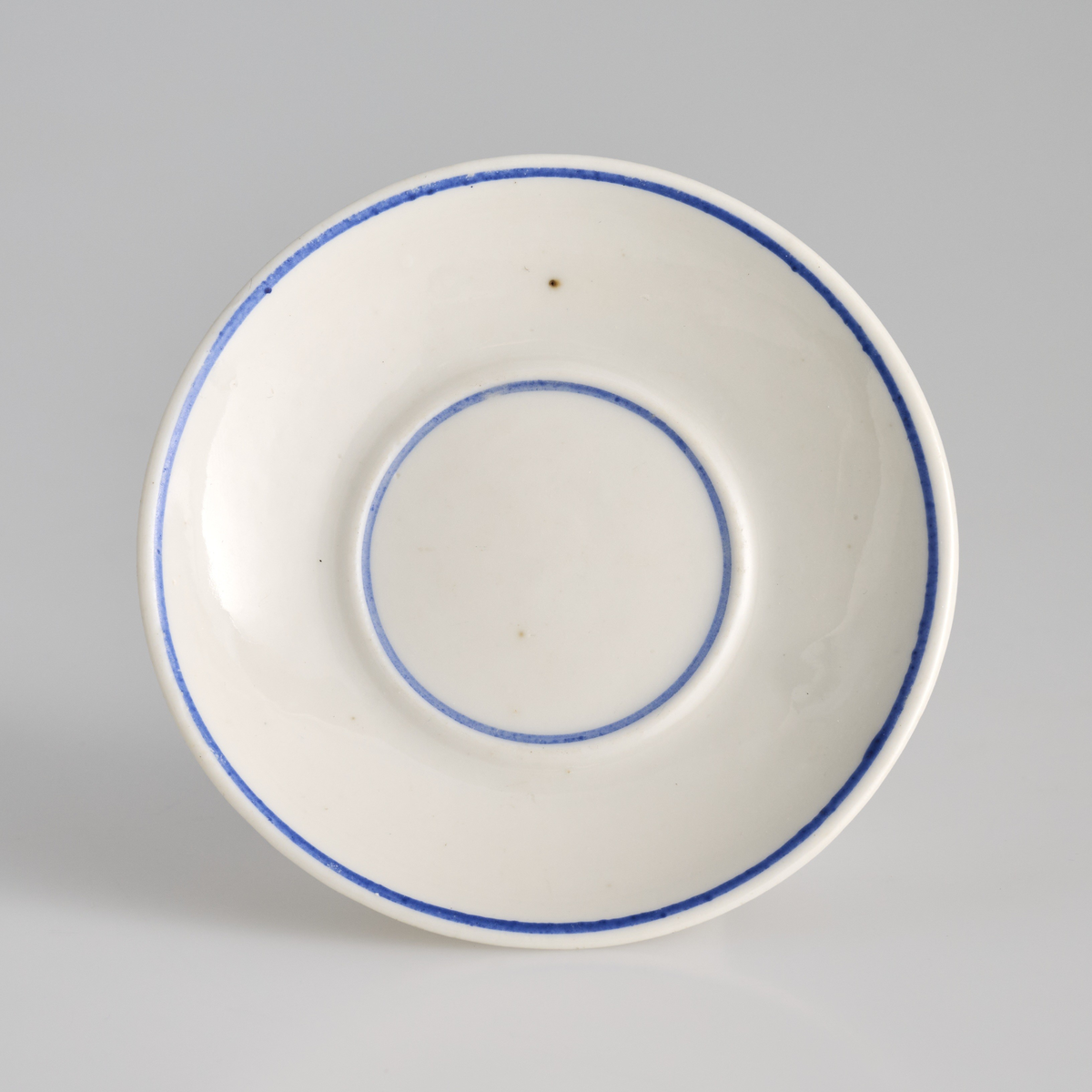 To like tallerkener brukt i lekestue på 1930-tallet. 
Tallerkenene er runde i formen, glasert hvite med blåe linjer langs toppen av kanten og langs fordypningen i midten av tallerkenene. På undersiden løper det en kant som danner en sirkel og utgjør foten av tallerkenene. 
Tallerken 01 er noe større enn 02. Bunnen av tallerken 01 er det gravert inn "3361", mens på tallerken 02 er det gravert inn "1868"