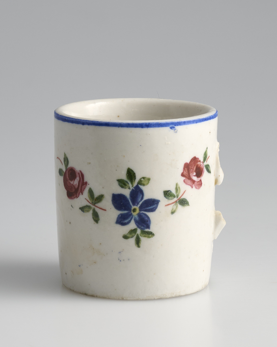 Tre tekopper brukt i lekestue på 1930-tallet.
Koppene er sylinderformet med øreformet hank festet midt på koppen. Kun kopp markert 03 har hel hank, på kopp 01 og 02 har hanken knekt av og kun festet sitter igjen.
Koppene er av hvit keramikk og er glasert blank med et påmalt motiv på framsiden. Motivet viser tre blomsterkroner med blomsterblader rundt; to roser med en blå blomst i midten. Tuppen av hanken og rundt toppen av kanten av koppen er malt blå.
På undersiden av koppene er tallet "3583" inngravert.
Koppene matcher en krukke med samme mønster.