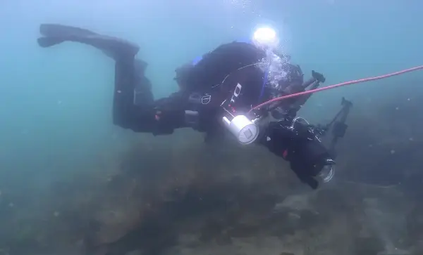Arkeolog Frode Kvalø dykker med kamera for å dokumentere skipet Minerva.