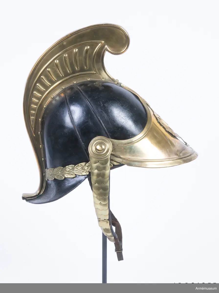 Lilla riksvapnet är pressat och fastsatt i plåten fram. Hela kasken är av en något lägre modell.