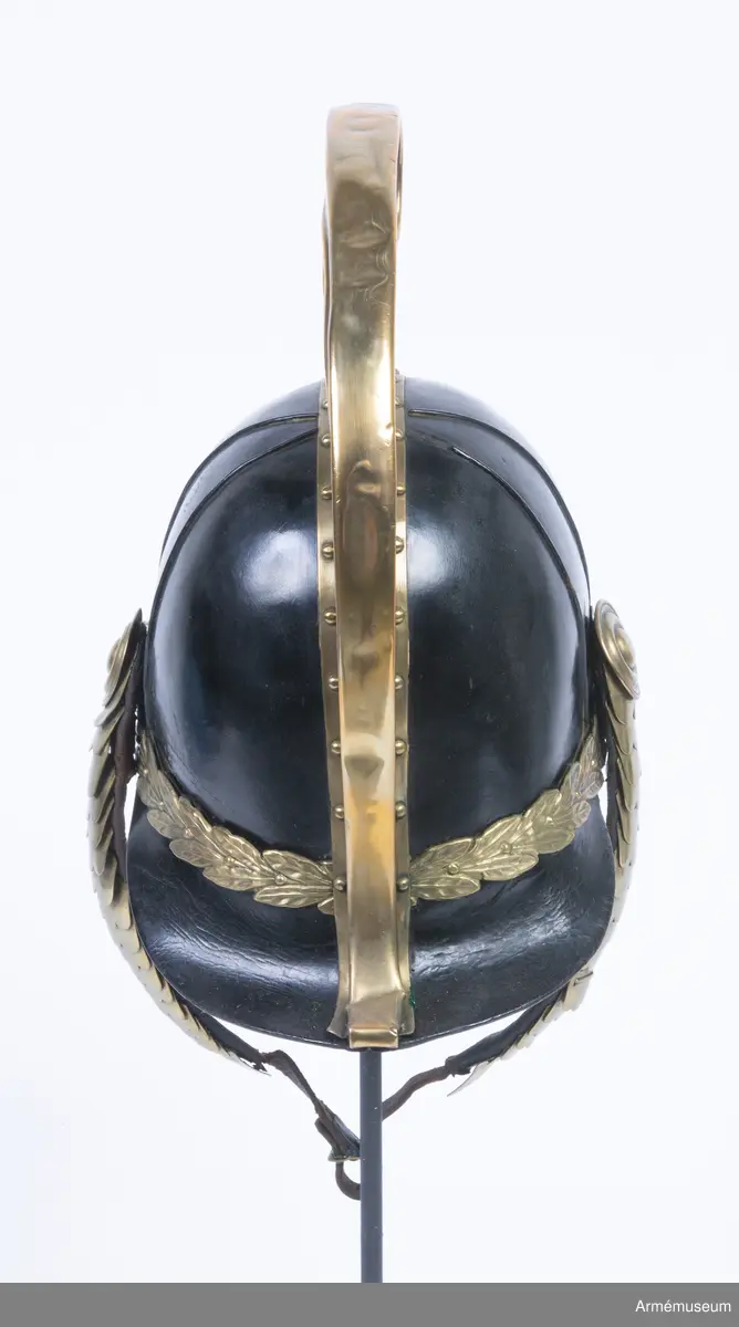 Lilla riksvapnet är pressat och fastsatt i plåten fram. Hela kasken är av en något lägre modell.