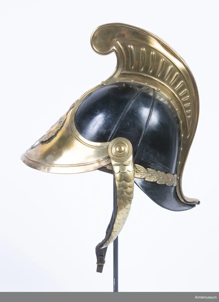 Lilla riksvapnet är pressat och fastsatt i plåten fram. Hela kasken är av en något lägre modell.