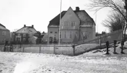 Några större villor med trädgårdar, längs en snöig slänt. By