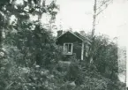 En sommarstuga som ligger i en backe vid en sjö, Strömsfors. Söderström 1937.