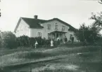 En familj har samlats framför sitt hus för att fotograferas i St Spånga, 1913.