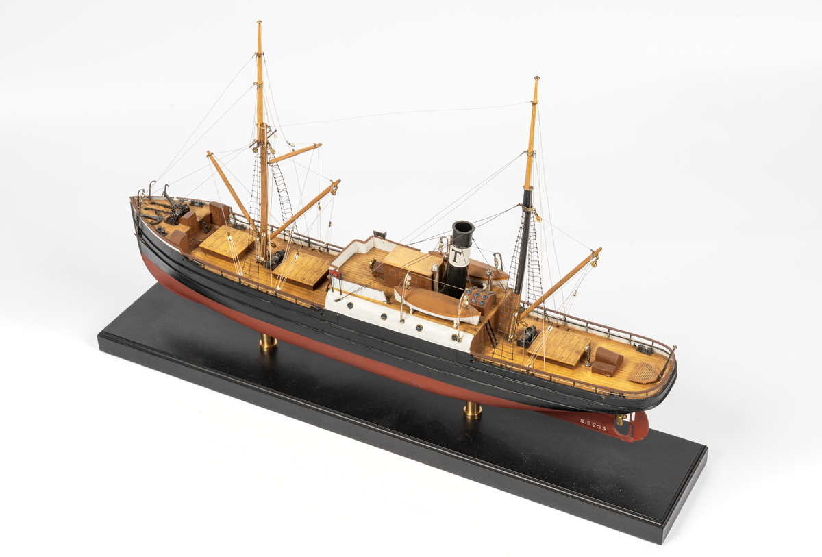 Fartygsmodell. Ångfartyget "CORFITZ BECK-FRIIS," Hel, i block av trä, fullt utrustad. Två master, tre lastbommar, en gaffel. Vitt skorstensbälte med svart T. Midskeppsbyggnad med runda vita sidor, öppen brygga, svart sida, röd botten.