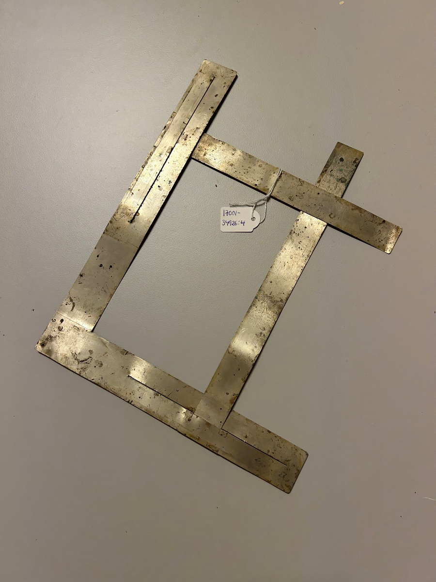 Remsor av tunn plåt bildar en rektangulär ram genom att två remsor sitter ihop vinkel. I dessa är två andra remsor fästade i utskurna spår. Eftersom dessa remsor är fästade i spår kan de flyttas  upp och ned vilket gör att ramen kan bli olika stor.