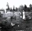 Foto av bivacken vid Mårdnäs beväringsrekrytskolan med både män och kvinnor, det ser ut som dom ska laga mat till beväringarna, 1901