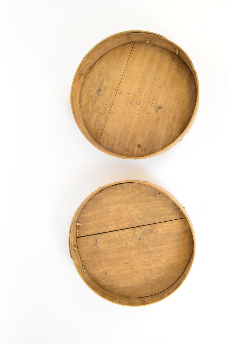 Gran. Sirkulær. Bunn og topp består av bord med spor langs kanten. Sidene, både i eske og lokk, utgjøres av bøyd spon, sydd sammen med tæger. Lokket er noe videre enn esken. Enkel sviornamentikk på innsiden av bunn og lokk, under bunnen og på sidene, rikere ornamentikk på lokkets overside. Sentralt sirkulært motiv, omgitt av fire kvadrater og fire rosetter. Buebord langs alle kanter.