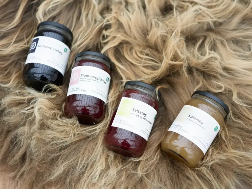 Fire glass med syltetøy ligger på et saueskinn. 