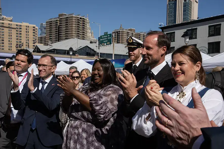 En liten gruppe kvinner og menn som klapper og smiler.