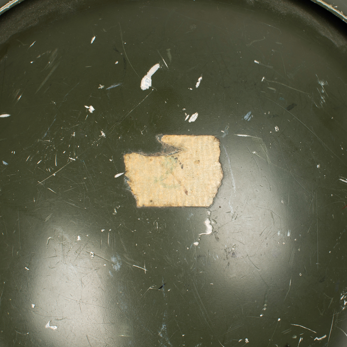 Flyghjälm SPH-4.
Grön flyghjälm med fast visirskydd av metall och tonat visir. Utksjutande form vid öronen för att ge plats för stora invändiga hörselkåpor. På vänster sida sitter en sladd för kommunikationsutrustningen, mikrofonen saknas. 
På visirskyddet sitter två runda klistermärken. Det högra med Forskningscentralens emblem med texten "SEMPER COMPERIEMUS", det vänstra är ett utbildningstecken för mörkerflygning inom marinflygning föreställande en svart fladdermus framför en blixt och en treudd samt text "SVARTA BARONERNA".