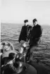 Tre män ombord på en u-båt.
På baksidan 