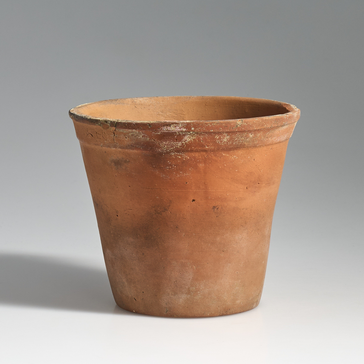 2 blomsterpotter i brent leire. Terrakottapotter med hull under i ca. lik størrelse. Ingen av pottene har jevnt fargemønster, men er alle preget av bruk. De begge har tilnærmet flat bunn.
Potte 02 har en sprekk som løper fra kanten av potten og skrått ned til bunnen.