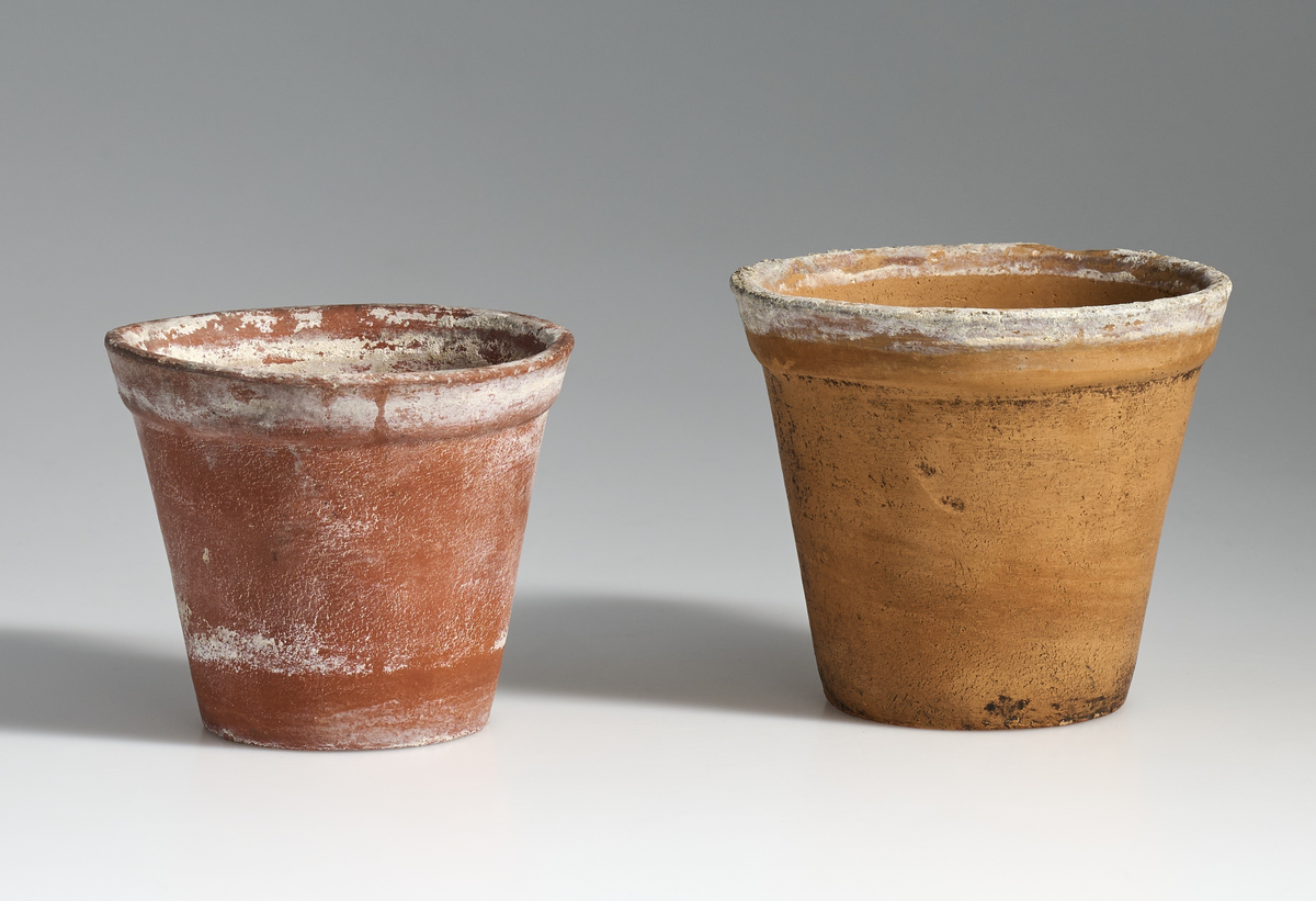 2 blomsterpotter i brent leire. Terrakottapotter med hull under i ca. lik størrelse. Ingen av pottene har jevnt fargemønster, men er alle preget av bruk. De begge har tilnærmet flat bunn.
Potte 02 er noe lysere og mer tilnærmet oransje i fargen enn 01, og litt høyre. Potte 01 er lavere og noe mer rødbrun i fargen enn potte 02.