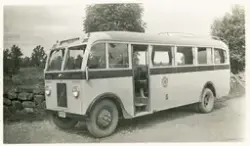 En buss har stannat till vid en stenmur (stengärdesgård) någ