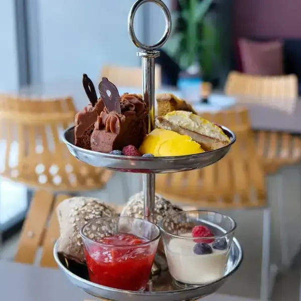 Et fat med småkaker, rundstykker og syltetøy.