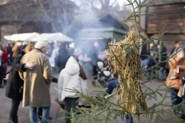 Publikum på julemarkedet på Norsk Folkemuseum. I forgrunnen henger et julenek på et lite grantre. 