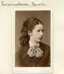 I raden av döttrar föddes Vendla Emanuelsson i Hällestads präktiga prästgård 1848. Det finns anledning till tro att kyrkoherden Per Jacob Emanuelsson och makan Charlotta Fredrika Haeger där skapade ett hem präglat av bildning och självtillit för sina flickor. Vendla blev lärare och från 1878 var hon i tjänst i Malmö. Efter några år flyttade hon till Stockholm, som blev hennes fortsatta plats livet genom. Hon avled som ogift 1922, då skriven på Lidingö. Här porträtterad i 30-årsåldern med klädsel och håruppsättning som bär 1870-talets prägel. Vi skriver omkring 1875.