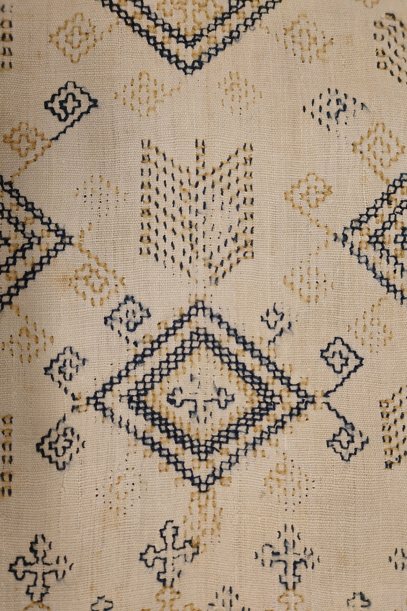 Julehandkle i grov lin med 15 cm brei firflettingsbord i nedre enden. Over heile handkledet er det brodert mønster i holbeinsting i blått og lys gulbrunt ullgarn. Enkelte plassar er ulltråden borte, slik at det står att berre merke etter den. Øverst på handkledet er det brodert 1774 (?) og bokstavane ILDV (?) i kjedesting. Desse er brodert med eit tjukkare ullgarn i gult.
Handkledet er falda i øvrekanten. og det er jarekantar i sidene.
I kanten øverst er det påsydd tre små hemper for å henga opp handkledet. Fint stoppa i endane øverst.