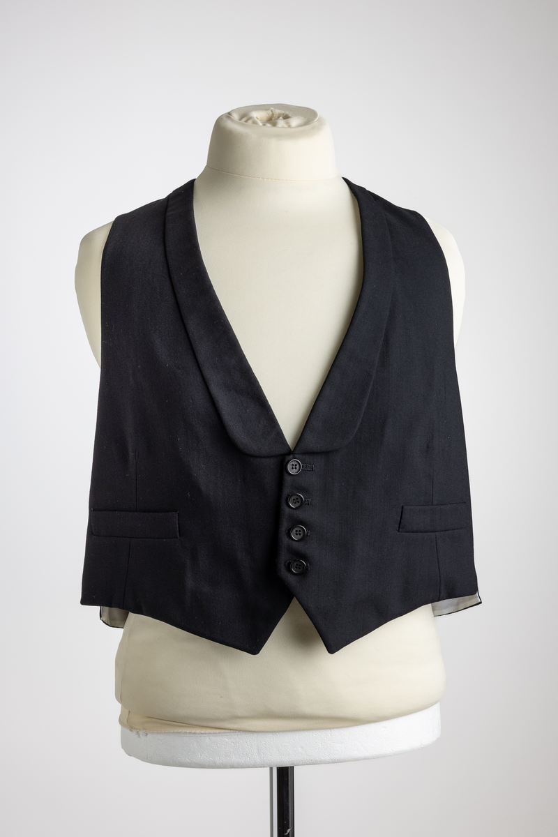 Konfirmasjonsdress i flere deler, jakke, bukse og vest, ifølge inntaksskjema. Stilmessig er det usikkert om vesten hører sammen med buksen og vesten..