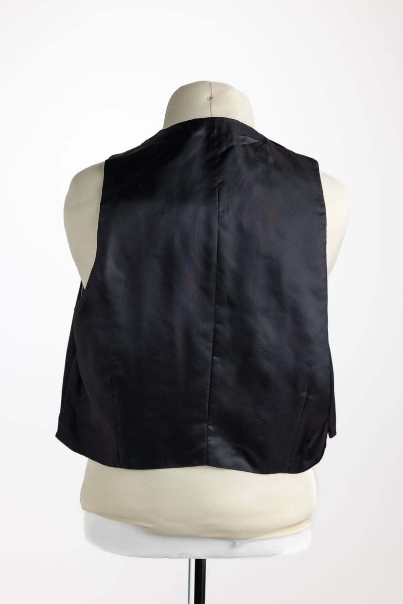 Konfirmasjonsdress i flere deler, jakke, bukse og vest, ifølge inntaksskjema. Stilmessig er det usikkert om vesten hører sammen med buksen og vesten..