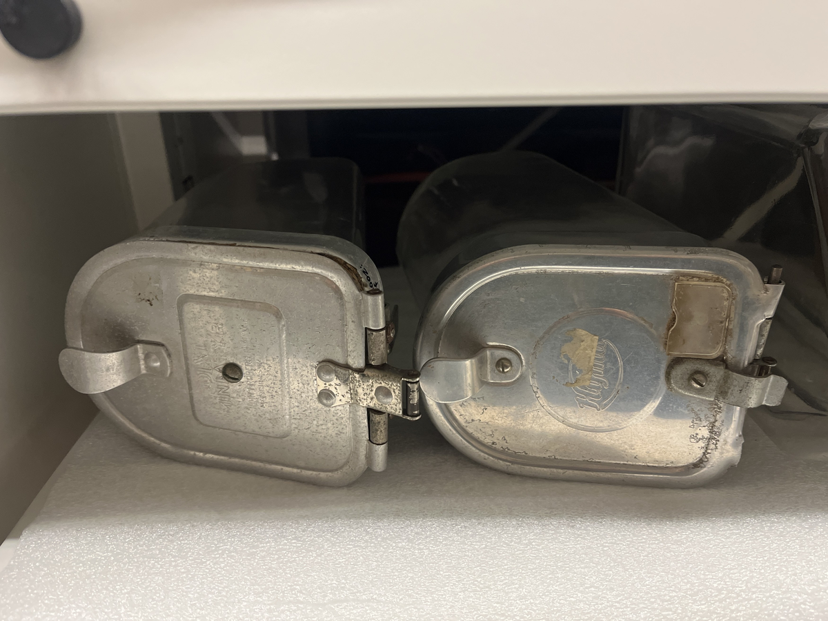 Ställ och glasbehållare för försäljning av karameller. 
a. Svart metallställning.
b-g. Glasbehållare med lock av aluninium. Locken öppnas genom att fällas ner. Text på några av locken "DIX Miniatyr AB JOHN FRÖBERG FINNSPÅNG".
h. Skopa av alumunium.

Från Arne Ekströms handelsmuseum.